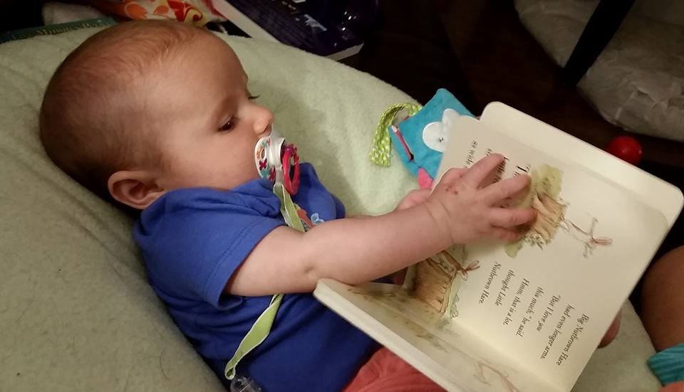 Photo of baby holding a book