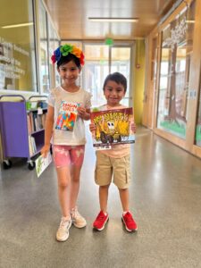 A girl and a boy at the Ferndale Library posing with books