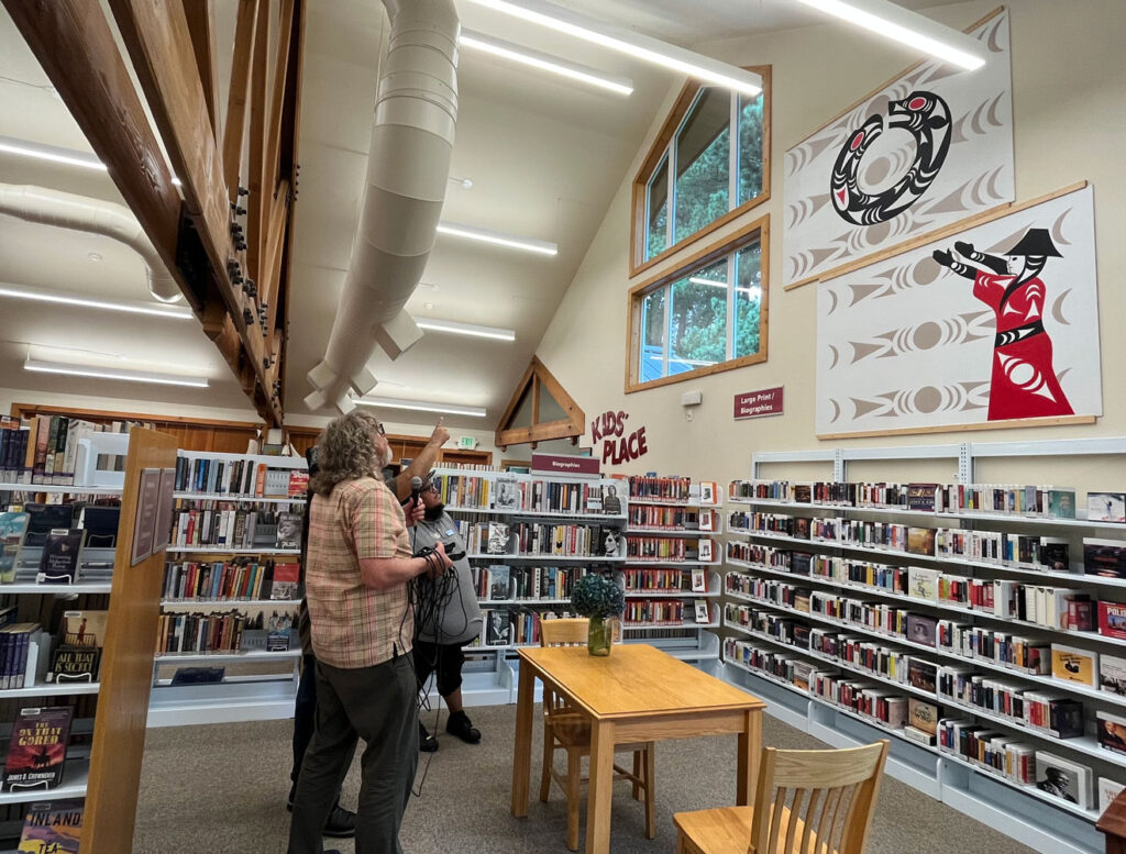 Jason LaClaire, Marty Jimmy and Neil McKay looking at Jason's murals in the Deming Library