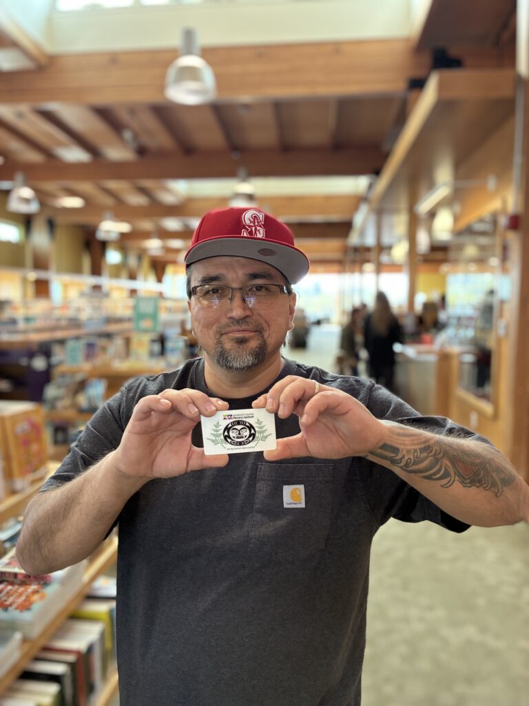 Jason LeClair holding a library card he designed