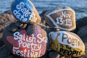 Painted rocks on a beach with sea in background. Rocks say "Save the Date," "Nov 13-15," "Salish Sea Poetry Festival," and "Poetry to the People"
